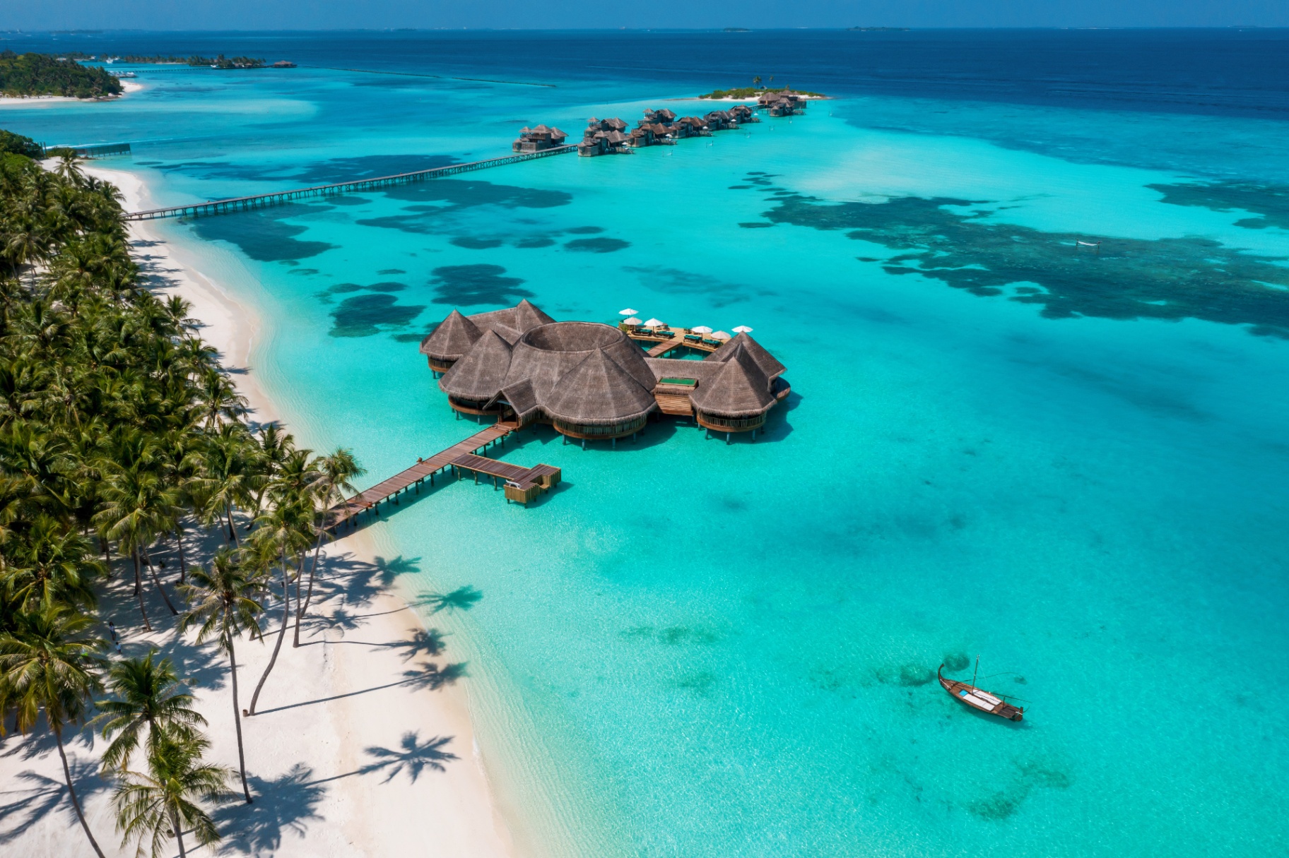 Aerial view of a luxury overwater resort at sunset